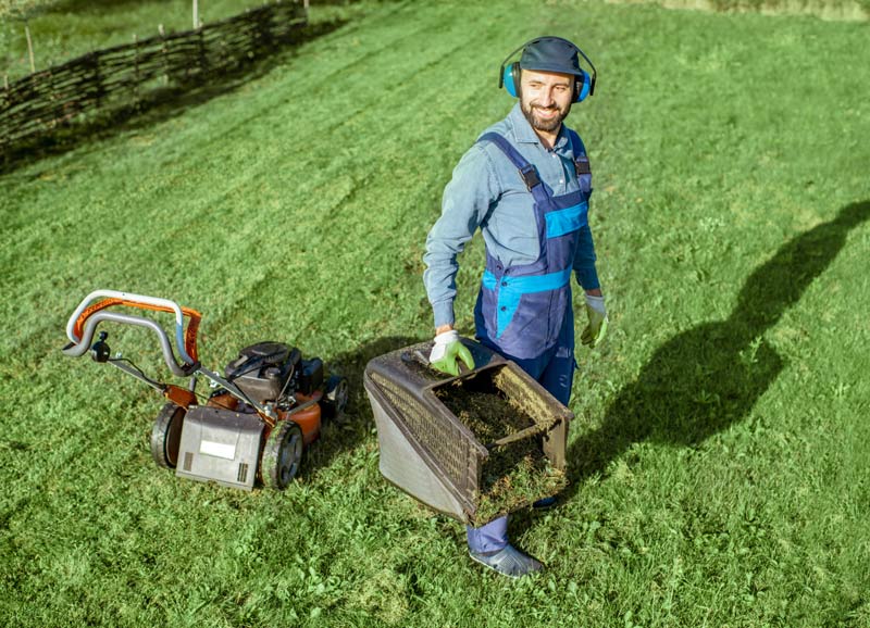 Jardinier tond sa pelouse en automne