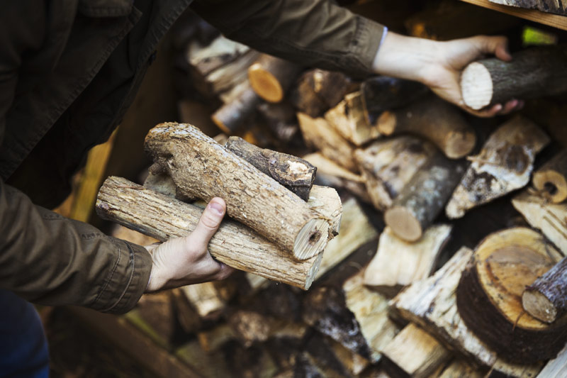 Homme stocke ses buches pour le chauffage au bois de l'hiver